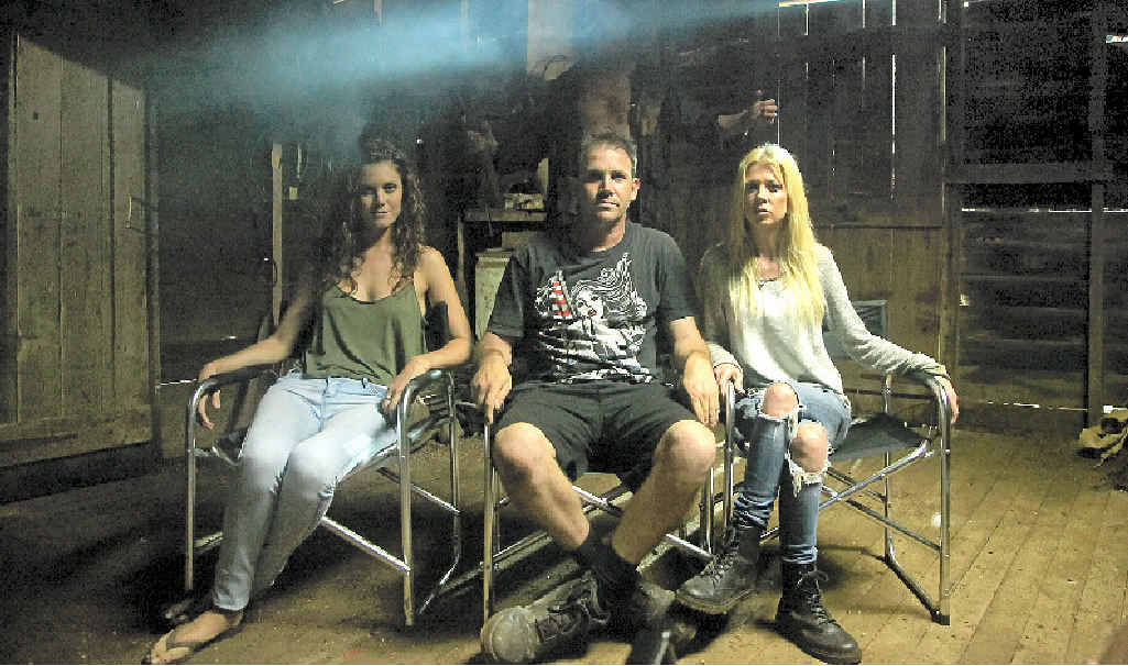 SCREAM TEAM: Charlie’s Farm writer Chris Sun (centre) with Allira Jaques and American Pie star Tara Reid, with Aussie killer Nathan Jones hiding in the back ground as Charlie. SCREAM TEAM: Charlie’s Farm writer Chris Sun (centre) with Allira Jaques and American Pie star Tara Reid, with Aussie killer Nathan Jones hiding in the back ground as Charlie.